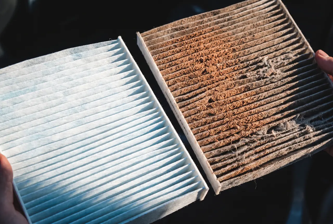A clean pleated air filter beside one clogged grey with Arizona desert dust